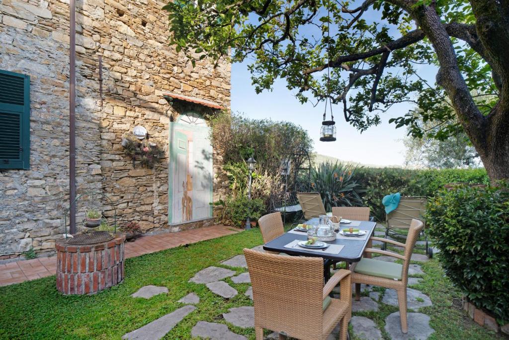 a patio with a table and chairs in a yard at Casa Maria in Dolcedo