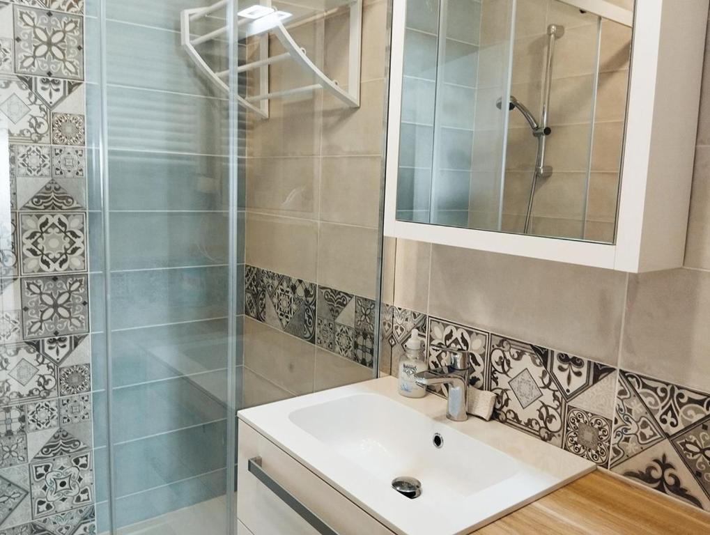 een badkamer met een wastafel en een douche bij Le Panorama de la Corniche in Saint-Hilaire-de-Riez