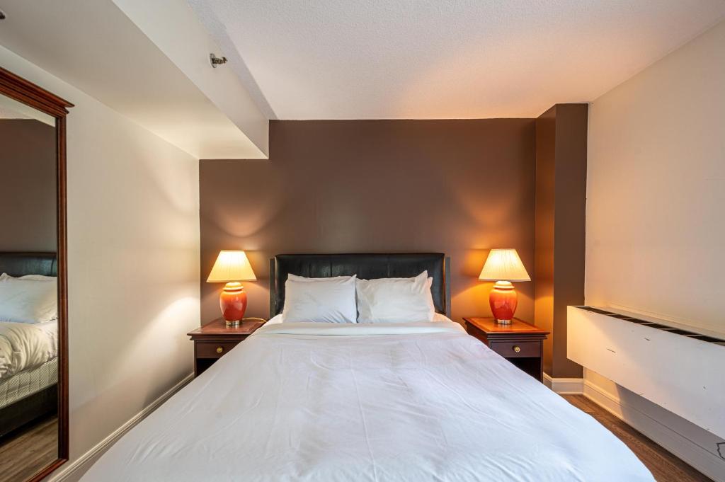1 dormitorio con 1 cama blanca grande y 2 lámparas en Le Bordeau à Saint-Sauveur, en Saint-Sauveur-des-Monts