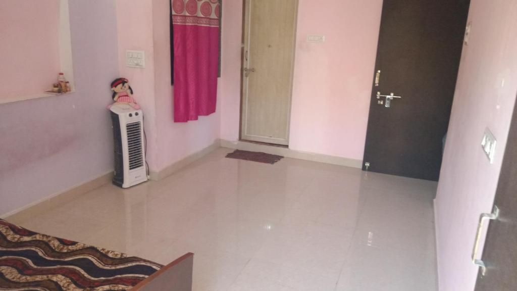 a living room with a radiator and a pink curtain at Dwarka Home Stay 2 Only family in Dwarka