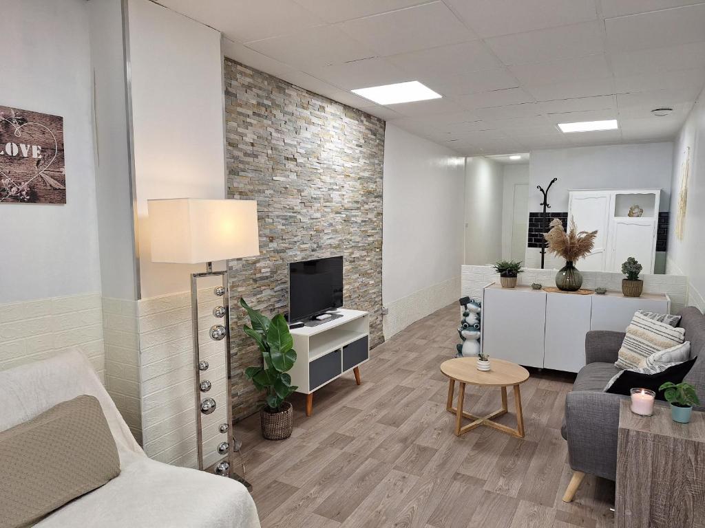 um escritório com uma sala de estar com uma televisão e um sofá em Chez Nous em Cherbourg en Cotentin