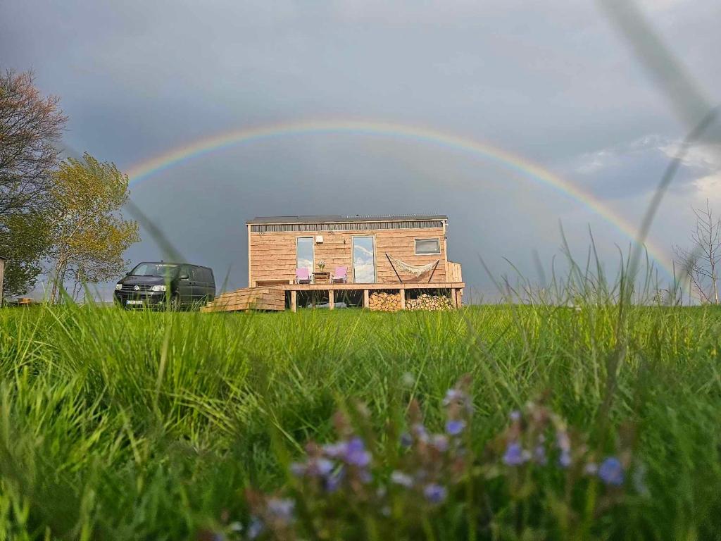 Un arcobaleno sopra una casa in un campo di Maringotka_naluke a Detvianska Huta