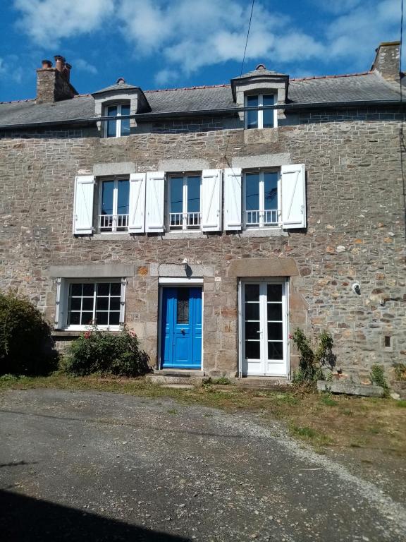 une vieille maison en briques avec une porte bleue et des fenêtres blanches dans l'établissement Kerfly, à Plouër-sur-Rance