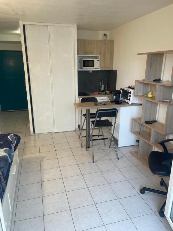 une cuisine avec une table et des chaises dans l'établissement Studio avec place de parking à la timone, à Marseille