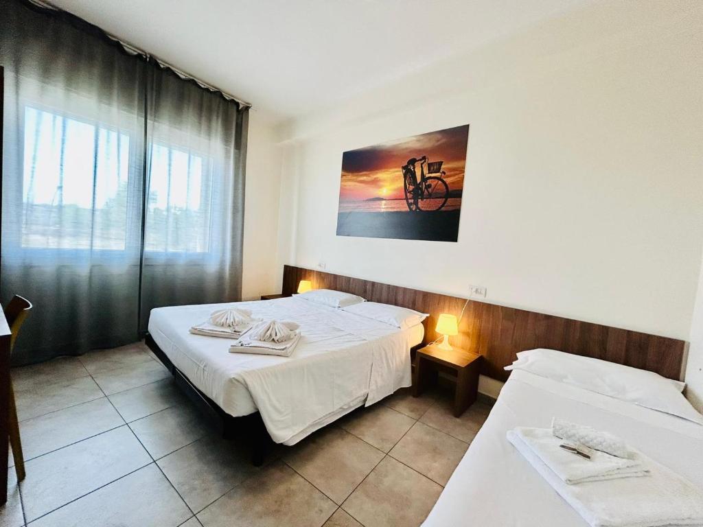 um quarto de hotel com duas camas e uma janela em Hotel Bed & Bike em Cesena