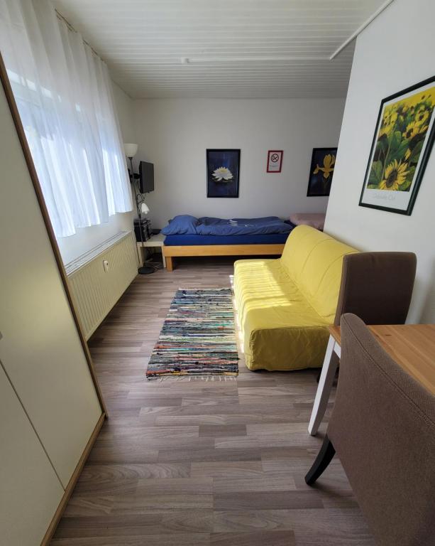 ein Schlafzimmer mit einem gelben Bett und einem Fenster in der Unterkunft Messezimmer am Thewissenweg in Düsseldorf