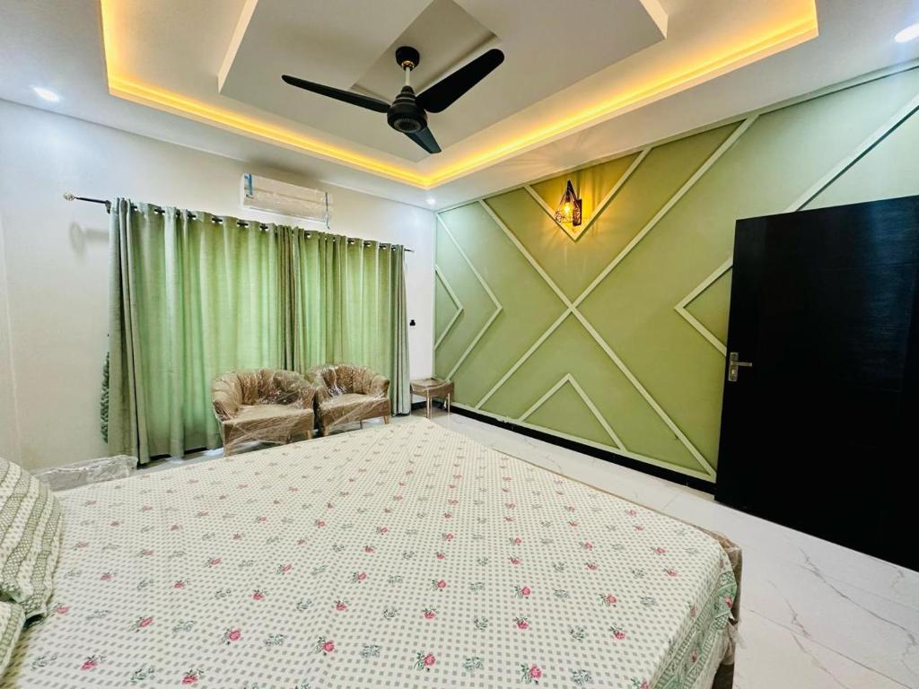 Luxurious kashmir house near Islamabad airport في Dhok Sandemār: غرفة نوم بسرير ومروحة سقف