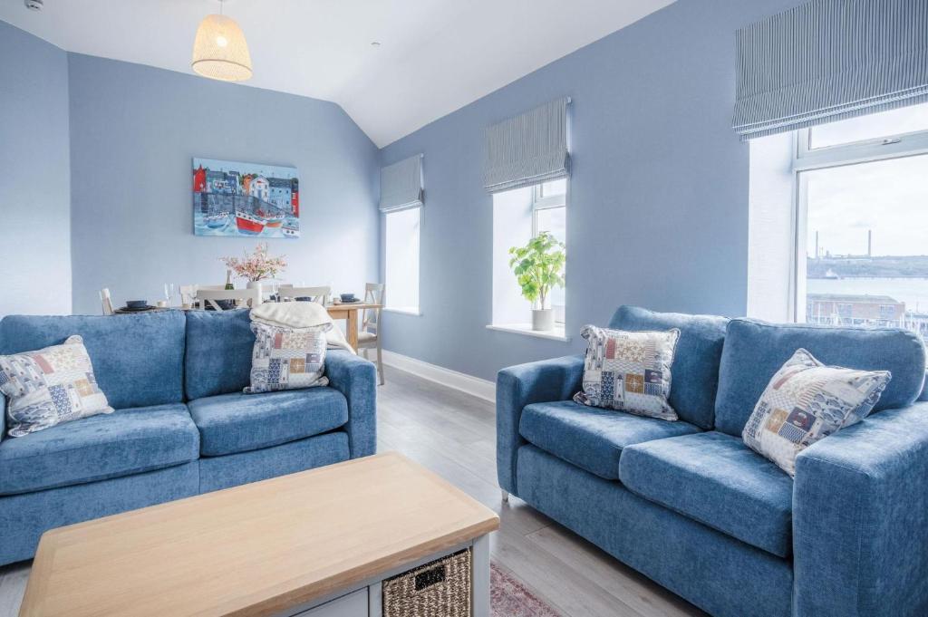 米爾福港的住宿－Harbour Heights - 2 Bed Apartment - Milford Haven，蓝色的客厅配有两张蓝色的沙发和一张桌子