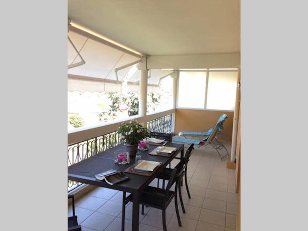 une salle à manger avec une table et des chaises sur un balcon dans l'établissement Hibiscus, à Cannes