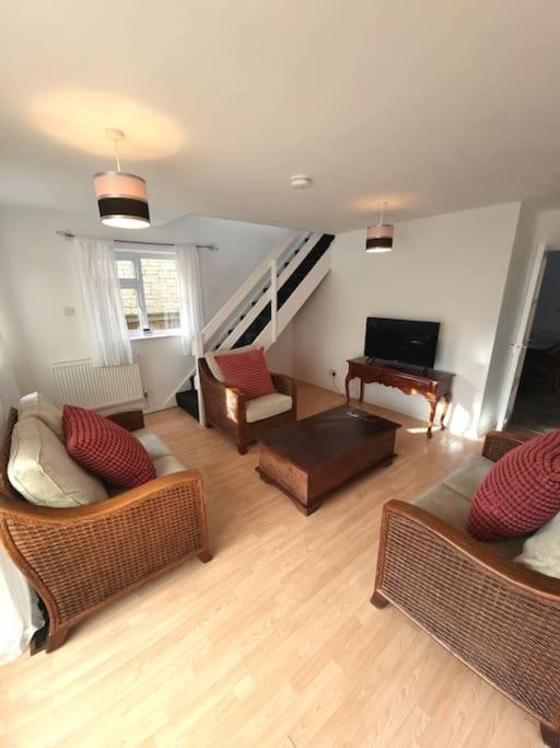 una sala de estar con 2 sofás y un piano en Home in Kington St Michael, en Stanton Saint Quintin