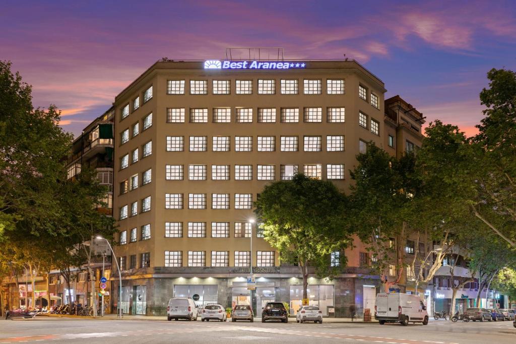 un rendimiento de un edificio con coches aparcados delante en Hotel Best Aranea, en Barcelona