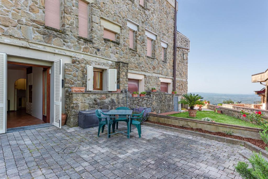 un patio con mesa y sillas frente a un edificio en Il Nido Toscano, en San Baronto