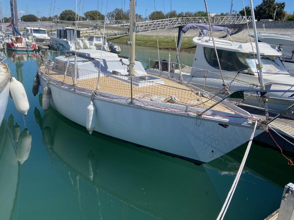 un barco atracado en un muelle en el agua en Nuit insolite dans un petit voilier en La Rochelle