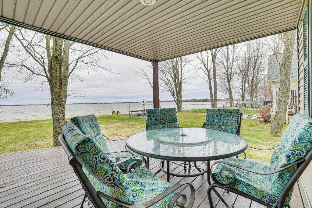 un patio con tavolo in vetro e sedie di Family-Friendly Houghton Lake House Steps to Lake a Houghton Lake
