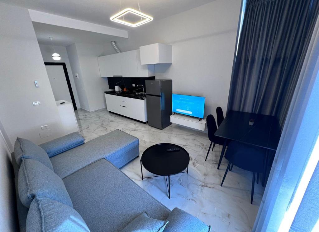 a living room with a blue couch and a table at Prime Luxury Apartments in Lushnjë