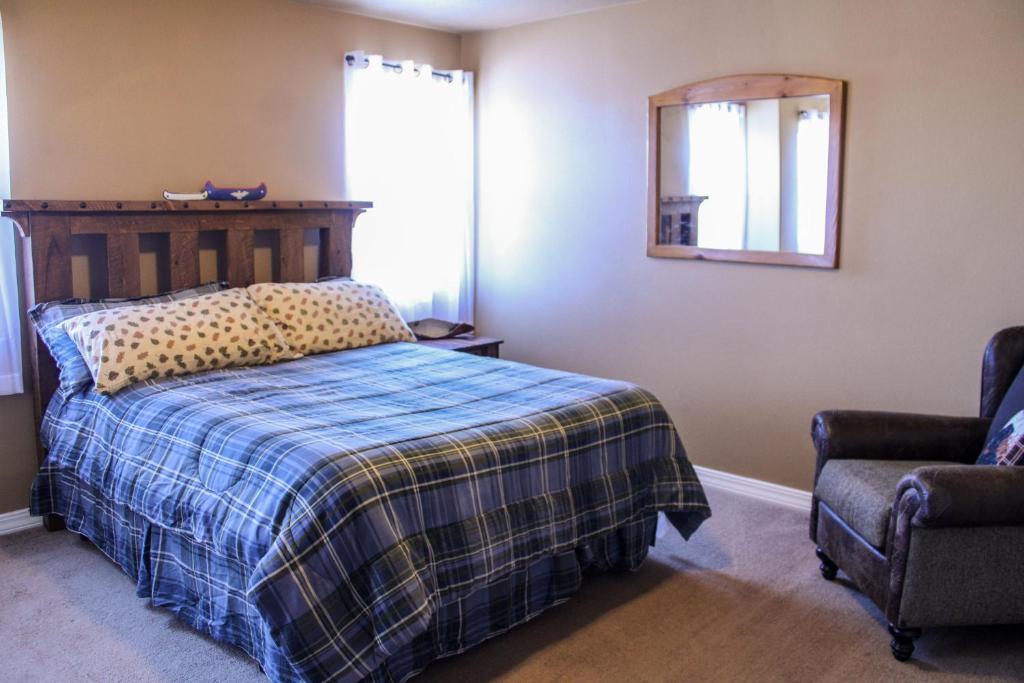 a bedroom with a bed and a mirror and a chair at City Lights Retreat in Sheridan