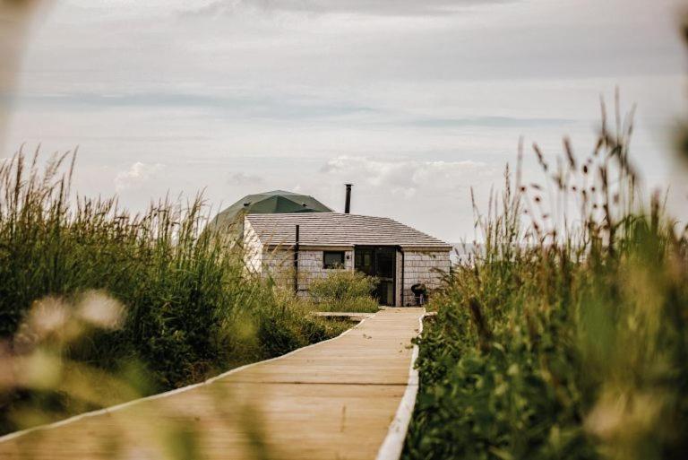 een houten loopbrug naar een huis in een veld bij Dome Meadows 2 At Tapnell Farm in Yarmouth