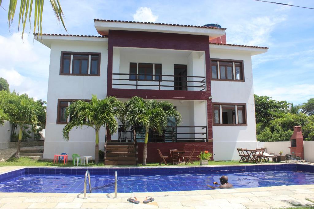 Villa con piscina frente a una casa en Sereia do Mar Pousada Carapibus en Jacumã