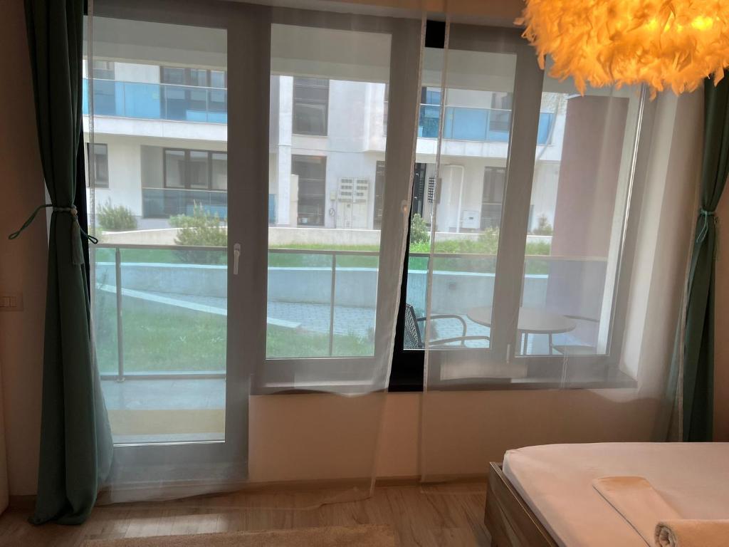 een kamer met een raam met uitzicht op een gebouw bij Garsoniera Genova in Otopeni