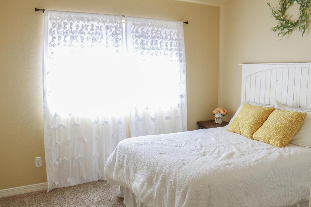 a bedroom with a white bed with a window at Chic Residence Near DT Sheridan in Sheridan