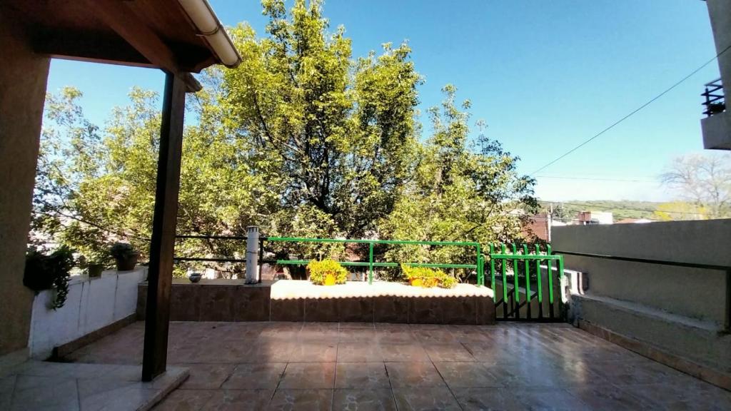 un porche con un banco con flores amarillas. en La casa del árbol en San Salvador de Jujuy