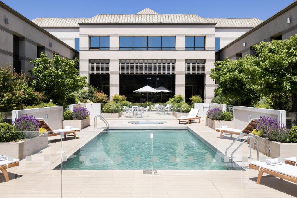 a swimming pool with chairs and a building at Holiday Inn Express - Temuco, an IHG Hotel in Temuco