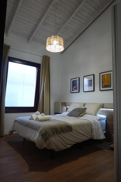 a bedroom with a large bed and a window at Apartamento Casa Dalí in Jerez de la Frontera