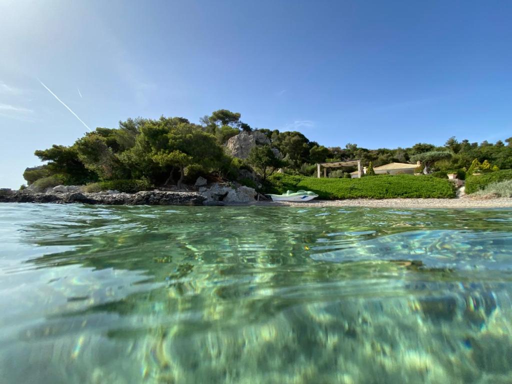 a view from the water of a small island at Villa Christina Luxury in Vouliagmeni Lake