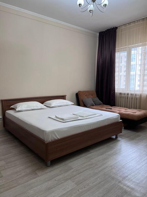 una camera con un grande letto e un divano di 215 Рядом с Байтереком для 1-6 чел, кондиционер, 2 большие кровати и диван a Astana
