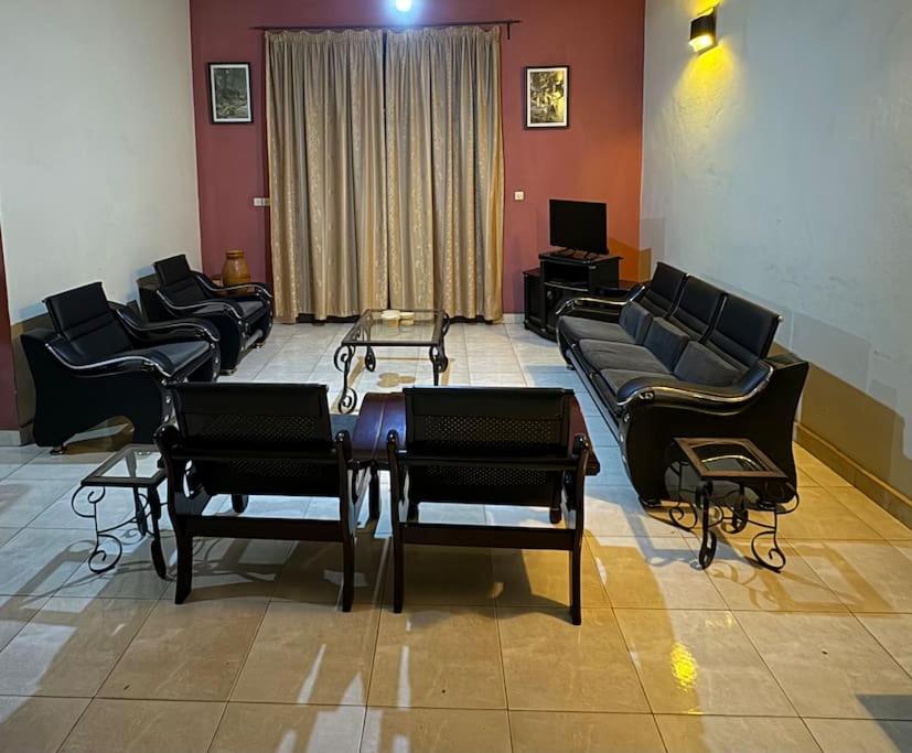 a waiting room with couches and a table and chairs at Oasis Urbaine 3 Chambres, Mixte in Bujumbura