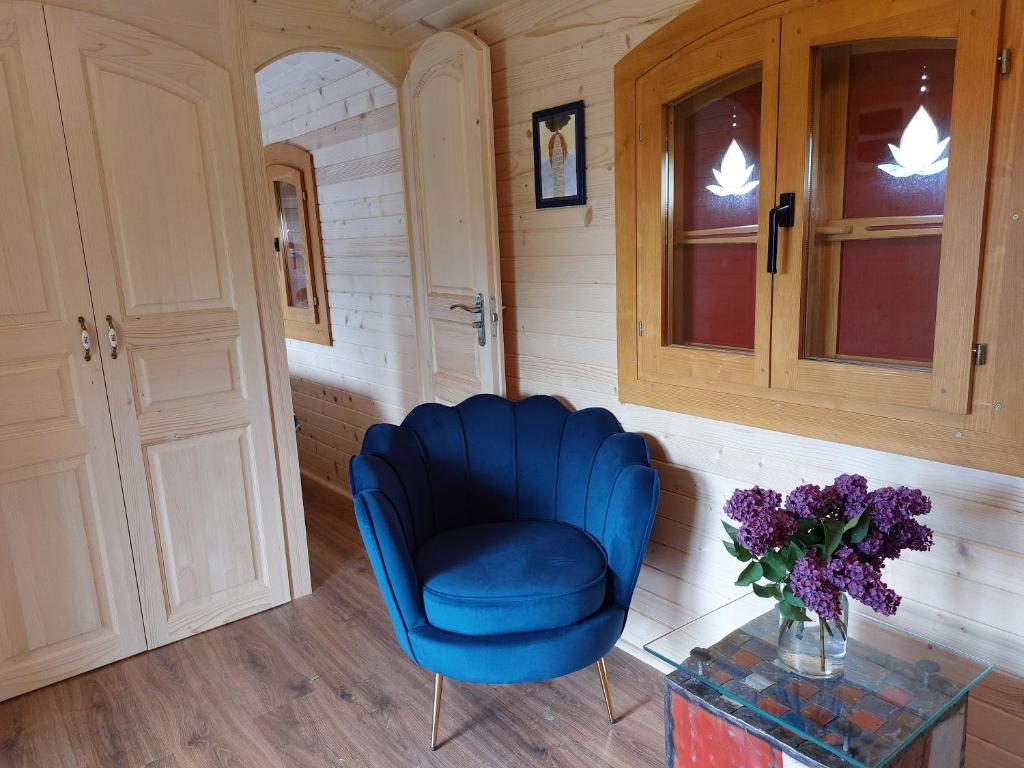 a blue chair and a glass table in a room at Roulotte ZEN in La Saunière