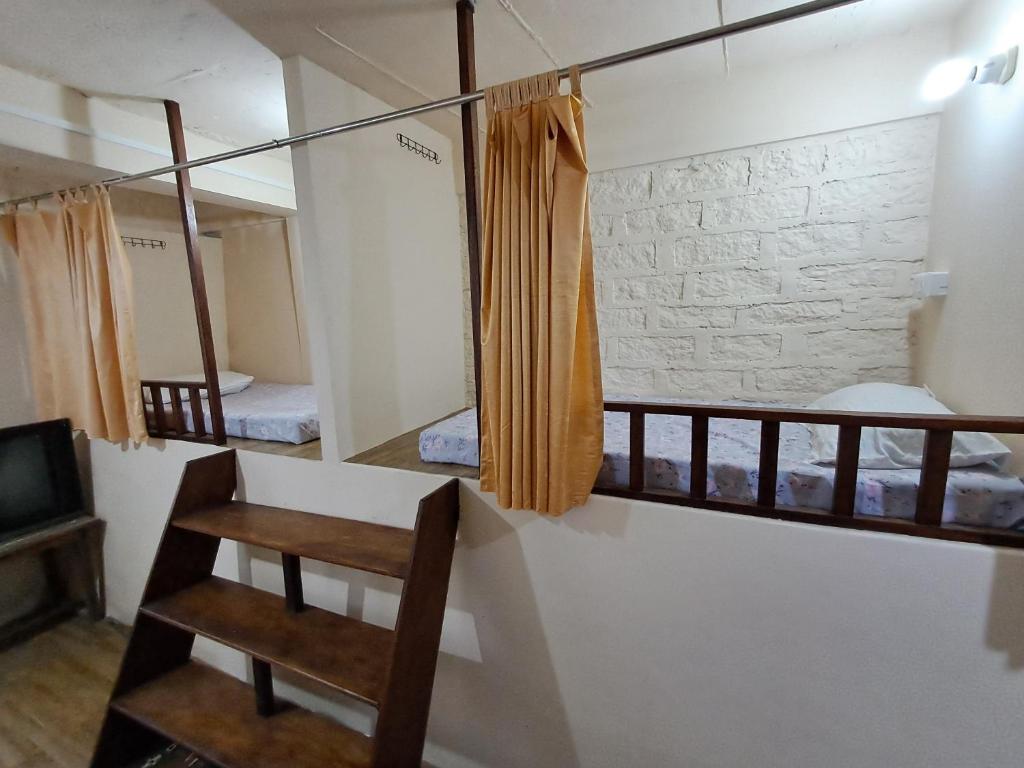 Pokój z 2 łóżkami piętrowymi i telewizorem w obiekcie Dormitories/Hosteller, Giftland Homestay w Aizawl