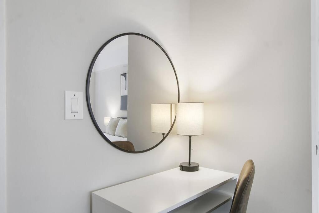 a mirror on a wall above a table with a lamp at 3BR Vibrant Apartment in Hyde Park - Bstone 5310-1 in Chicago