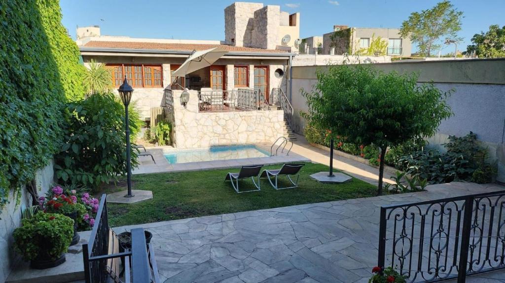 a house with a pool and two chairs in the yard at Hotel Boutique Casa & Cava in Mendoza