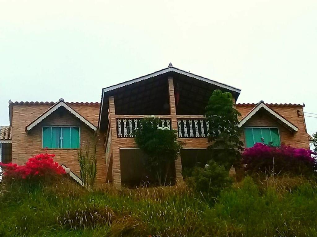 a house with green shuttered windows on a hill at Pousada Linda Vista in Domingos Martins