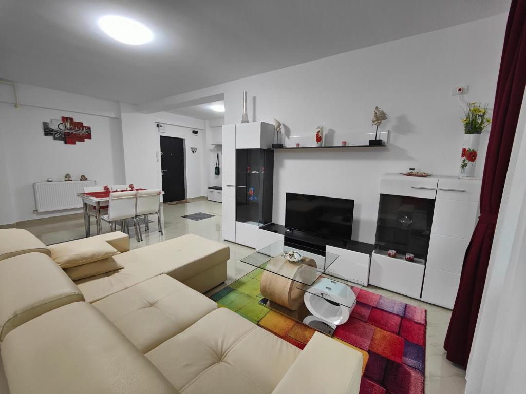 a living room with a couch and a tv at Apartament Delfin - 100m de la plaja in Mamaia Nord