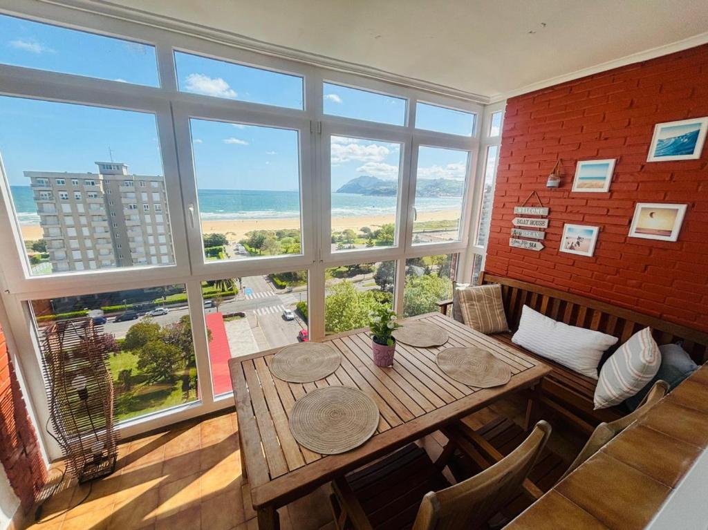 uma sala de jantar com uma mesa e uma grande janela em APARTAMENTO el PUNTAL- LAREDO em Laredo