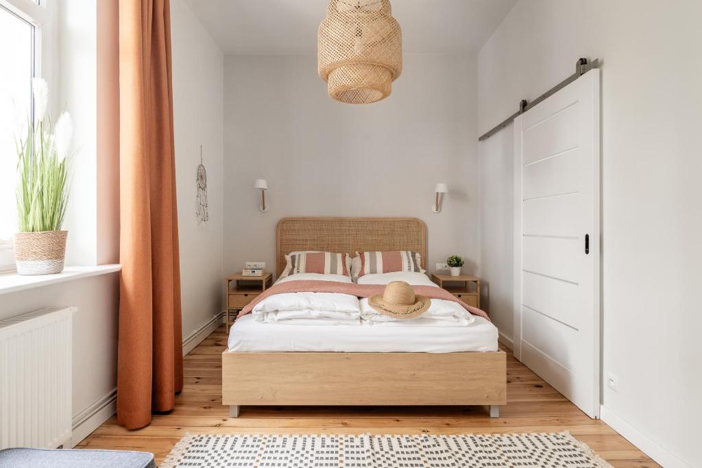 a bedroom with a bed with white walls and an orange curtain at Sanhaus Apartments - Apartament Kite and Surf przy plaży in Sopot