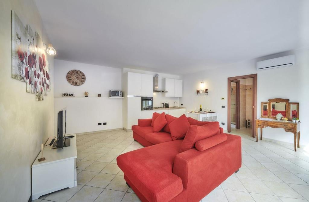 - un salon avec un canapé rouge et une télévision dans l'établissement La casa di Cinzia central apartment, à Lierna