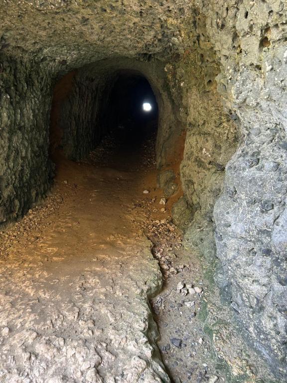 a dark tunnel with a light at the end of it at Villa Roc Vaudieu - Charmante maison de pêcheurs in Étretat
