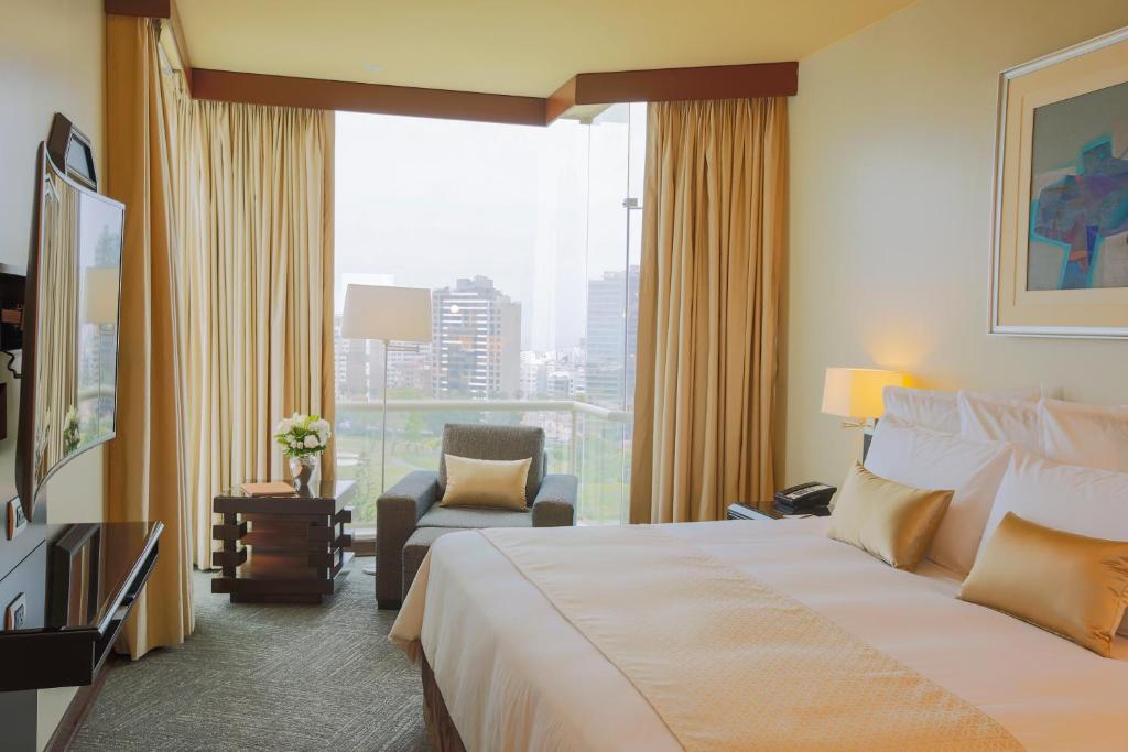 Habitación de hotel con cama grande y ventana en Delfines Hotel & Convention Center en Lima