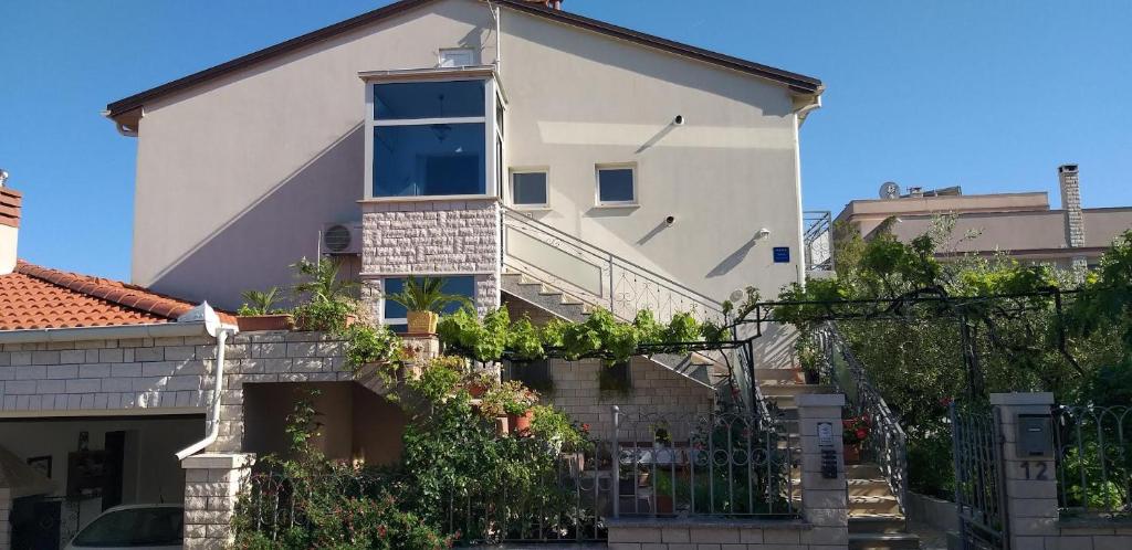 a large white house with plants on the side of it at Apartman Oliva in Pula