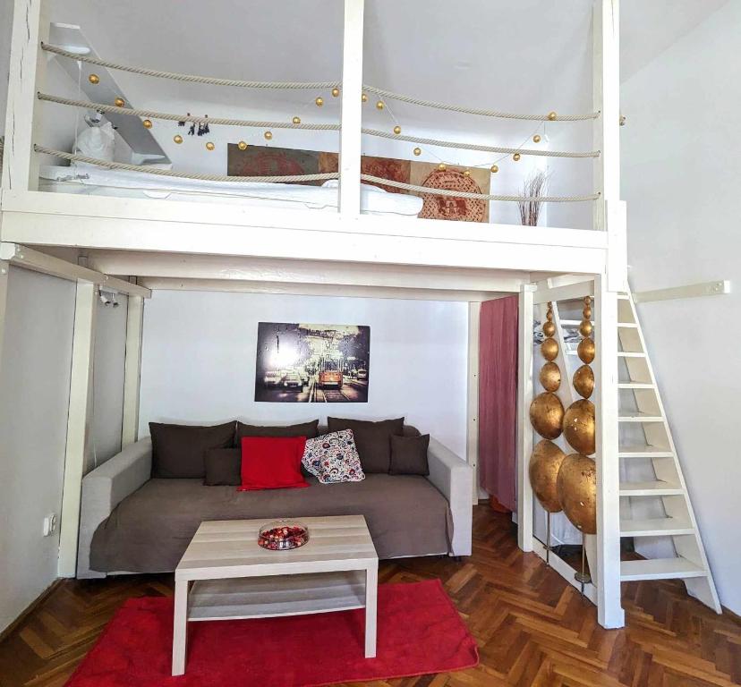 a bedroom with a bunk bed with a couch and a table at Gallery flat in Party district in Budapest