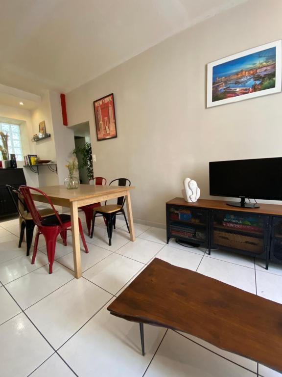 un salon avec une table et une télévision dans l'établissement Charmant appt Endoume - proche mer et Vx Port, à Marseille
