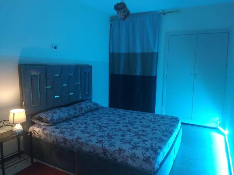 una camera con un letto in una camera blu di APPT DE LUXE a Rabat