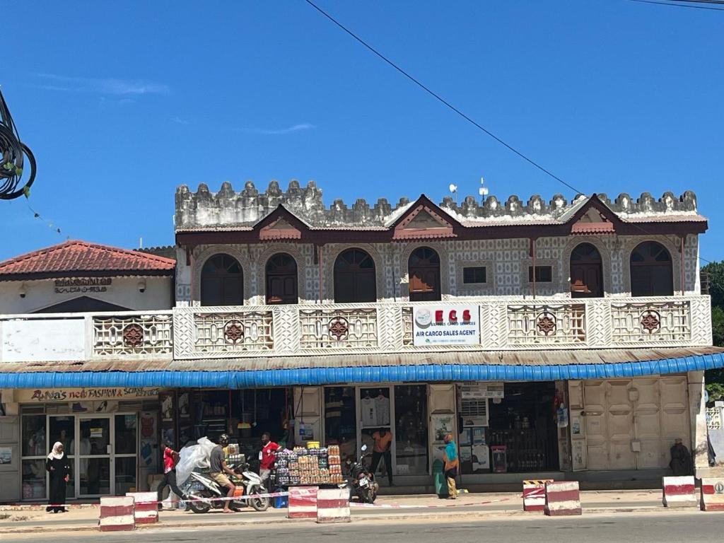 un edificio con estatuillas encima en una calle en Wonder house zanzibar, en Kiembi Samaki