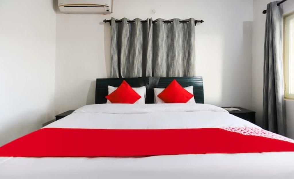 a bed with red pillows in a room at Ram Homestay in Kangra