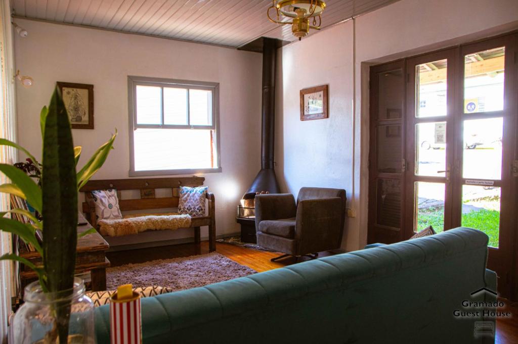 uma sala de estar com um sofá e uma cadeira em Gramado Guest House em Gramado