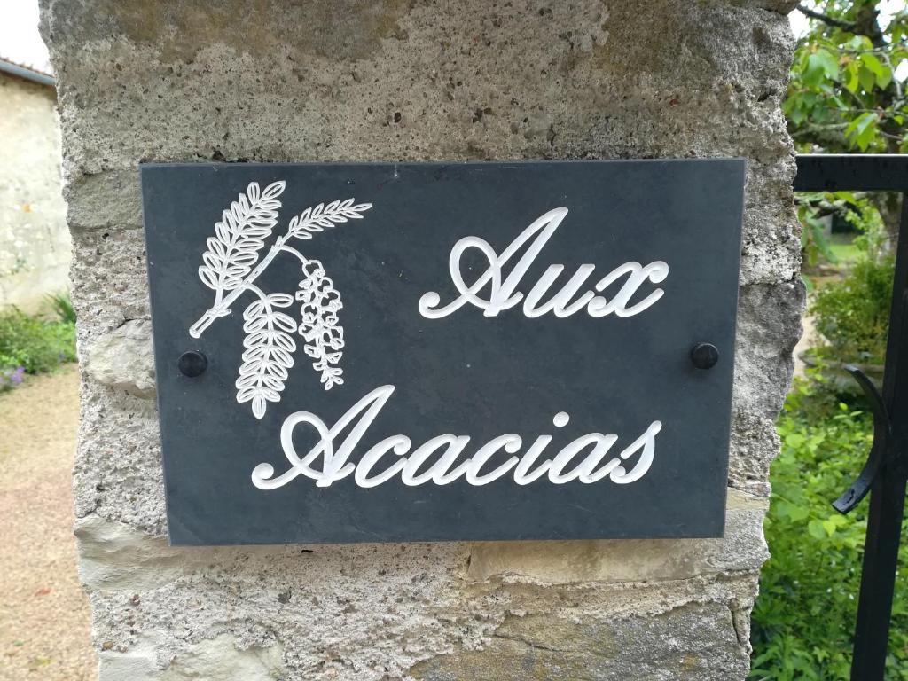 una señal en el costado de una pared de piedra en Aux Acacias en Braye-sous-Faye