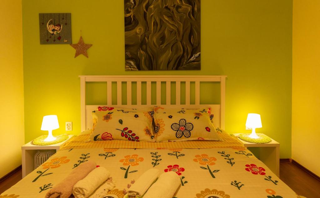 a bedroom with a bed with yellow walls and two lamps at Apartman More in Novigrad Dalmatia